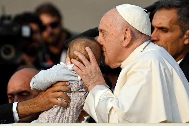 Papst Franziskus küsst ein Baby bevor er mit kranken Jugendlichen in der Erscheinungskapelle in Fatima das Rosenkranzgebet leitet. AFP