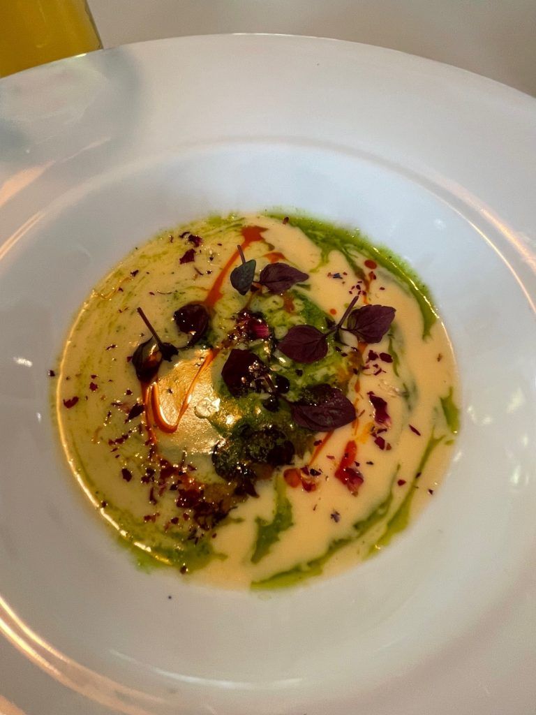Champagnercremesuppe mit Kräuterschaum und Paprikaöl.