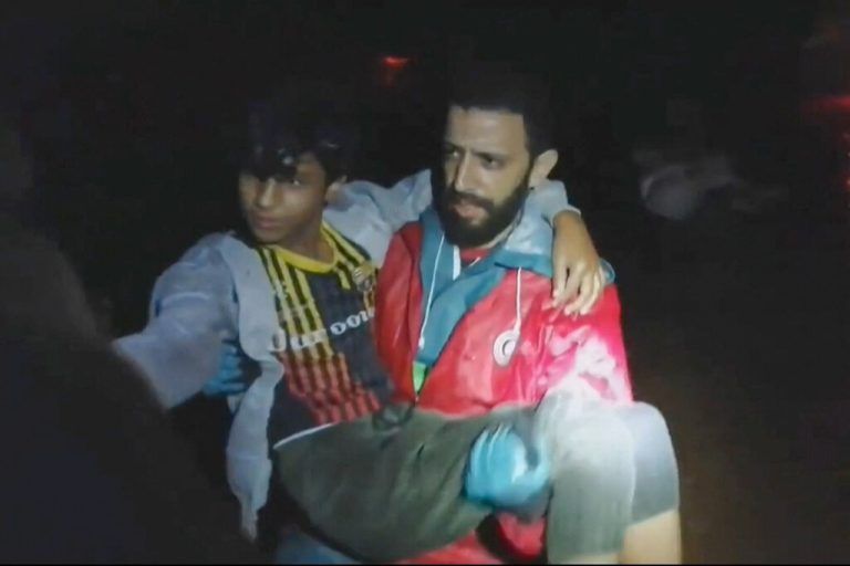 Ein Mitglied der Hilfsorganisation Roter Halbmond rettet einen Jungen. ap