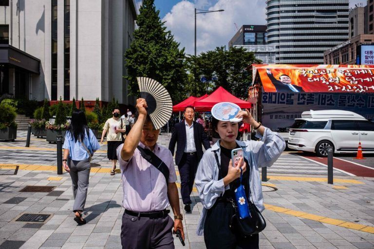 Mit Fächern versuchen sich diese Fußjänger in der südkoreanischen Hauptstadt Seoul vor der Sonne zu schützen. AFP