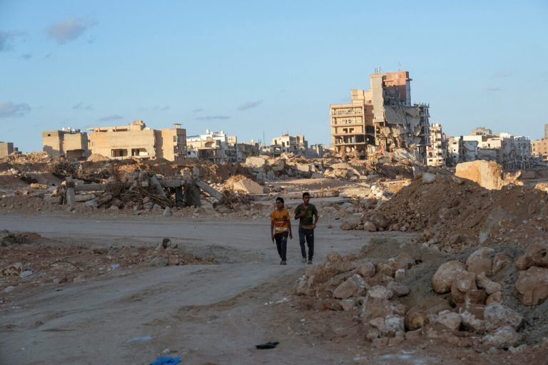 Nach den verheerenden Überflutungen: Jungen laufen durch die Trümmer der Stadt Derna in Libyen. Reuters