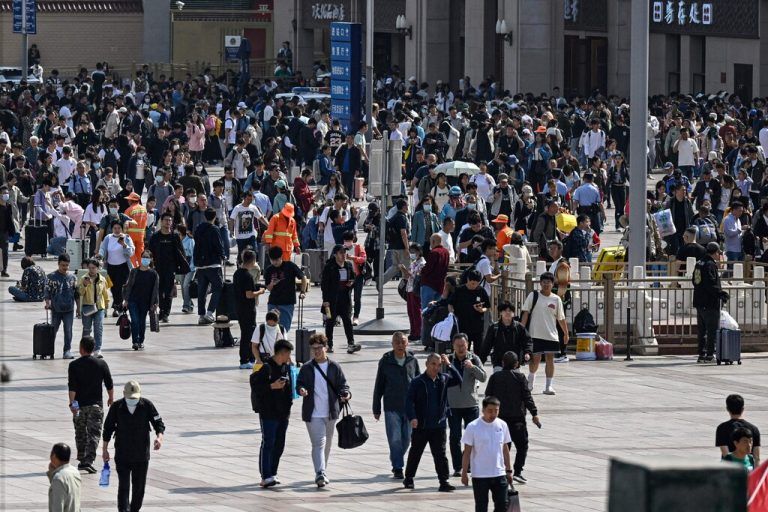 Zahlreiche Passagiere kommen am ersten Tag der Hauptreisezeit vor den Ferien zum Nationalfeiertag in Peking an. AFP