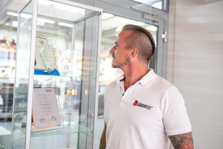 In der Glasvitrine im Eingangsbereich des Unternehmens präsentiert Michael Jäger die Auszeichnungen seiner Mitarbeiter. Darunter befindet sich auch ein Weltmeistertitel. <span class="copyright">VN/Rhomberg</span>