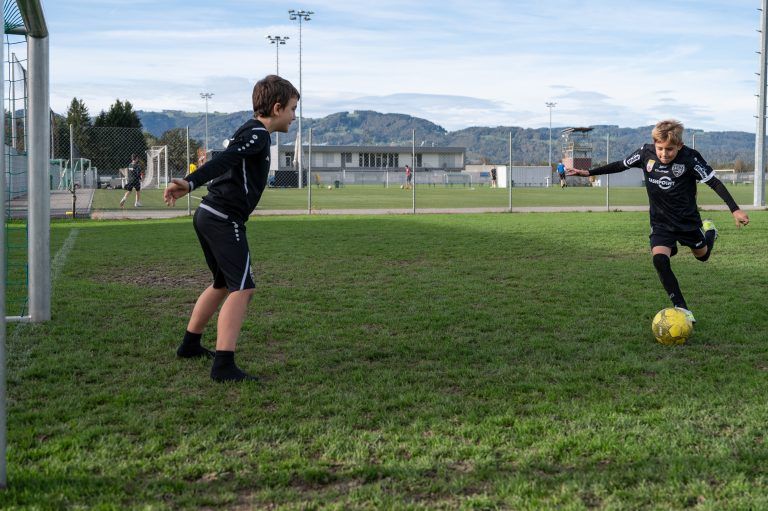 Die beiden nutzen die warmen Temperaturen für Fußballspaß.
