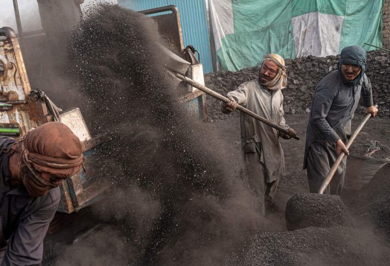 Afghanische Arbeiter schaufeln auf einem Kohlenlager am Stadtrand von Kabul Kohle auf einen Lastwagen. AFP