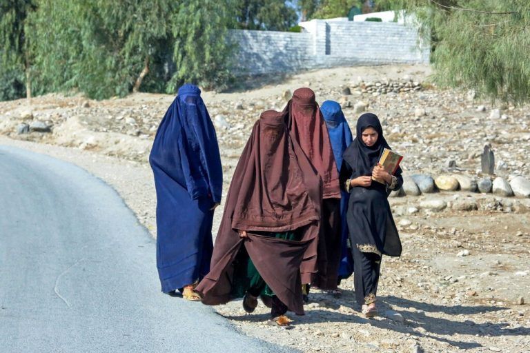 Afghanische Frauen gehen mit Burkas bekleidet eine Straße am Stadtrand von Jalalabad entlang. AFP