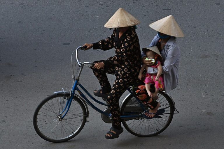 Eine Fahrradfahrerin transportiert in Can Tho City in Vietnam eine Frau und ein Baby auf dem Gepäckträger. AFP