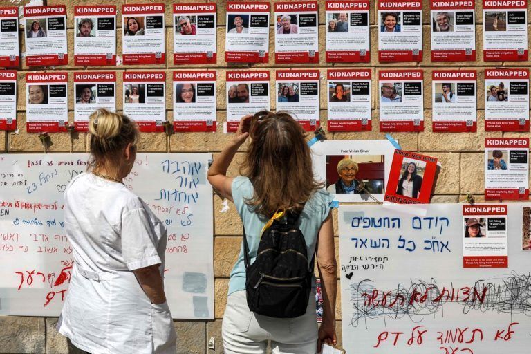 Eine Frau betrachtet in Tel Aviv Fotos der von der Hamas entführten Menschen. AFP