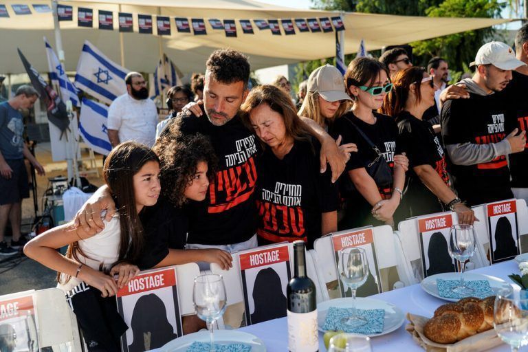 Familien von Menschen, die von den Hamas entführt wurden, warten in Tel Aviv an einem Tisch mit leeren Stühlen. Sie stehen symbolisch für ihre Lieben. Reuters