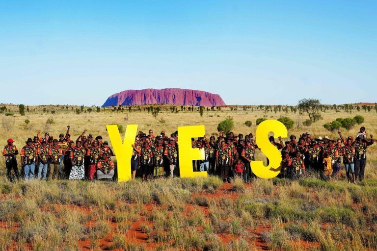 In Australien werben Menschen vor dem Ayers Rock für 