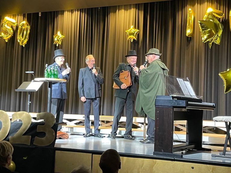 Vier Männer spielten die Vereinsgründung von 1873 als lustige Theaterszene nach.