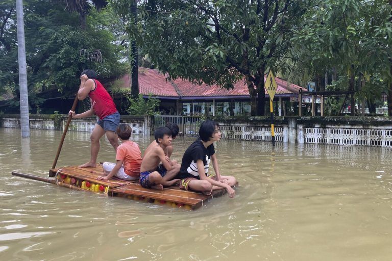 Mit einem Floß überqueren diese Bewohner in Bago (Myanmar) eine Straße. 10.000 Menschen sind vor dem Hochwasser auf der Flucht. AP