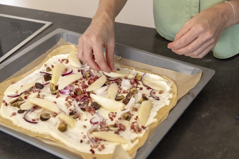 Bertsch beim Zubereiten eines Flammkuchens mit Maroni, Birnen, Speck und Gorgonzola.