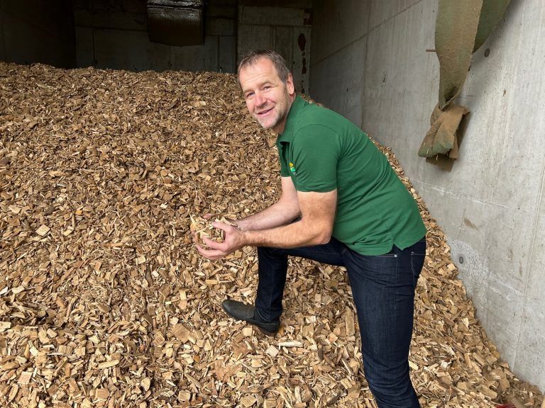 Tobias Ilg zeigt seinen Hackschnitzel-Vorrat. Auch der Preis für heimisches Holz<span class="copyright">VN/pes</span> ist nicht zweifelsfrei vorhersehbar, schwankt aber weniger als der mancher fossiler Brennstoffe.