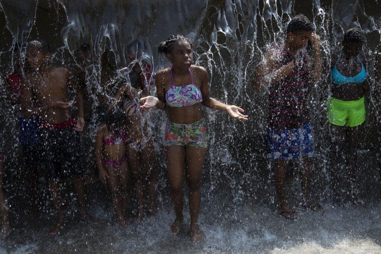 Diese Kinder und Jugendlichen suchen in Rio de Janeiro Abkühlung in einem Brunnen. AP