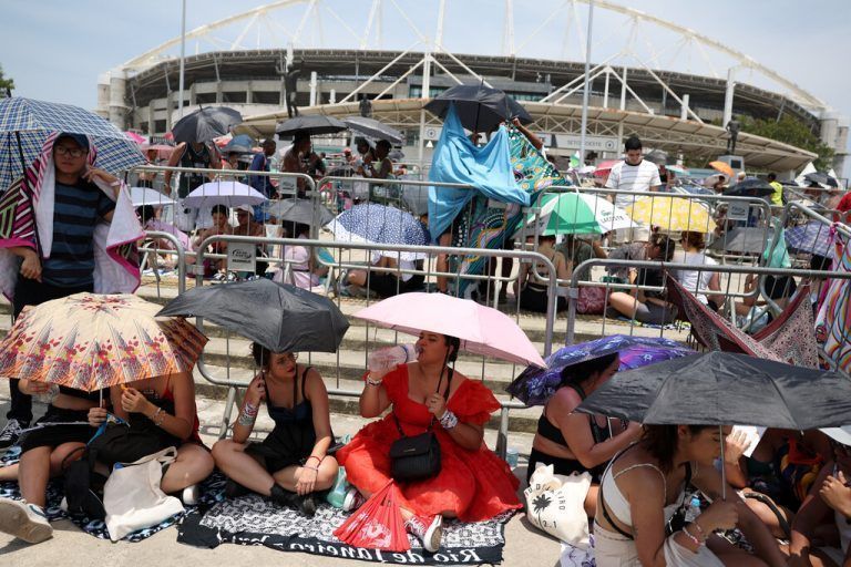 Fans von Taylor Swift schützen sich mit Sonnenschirmen, während sie auf den Einlass zum Konzert in Rio de Janeiro warten. Reuters