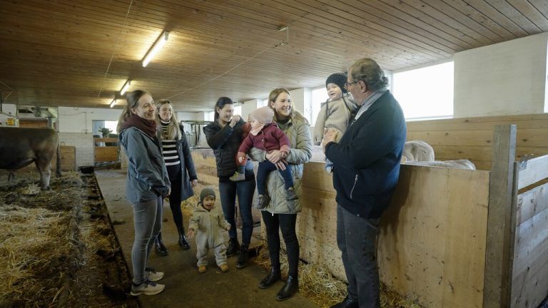 Hans Concin mit Frauen und Kindern im Stall. Er propagiert schon länger die Vorteile eines Aufenthalts auf einem Bauernhof. aks