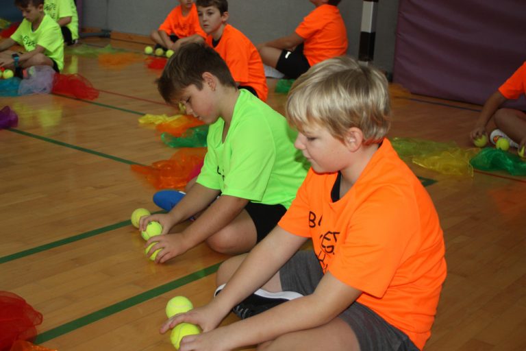 Schulsport in Aktion: Kinder üben Jonglieren mit Bällen bei der neuen Challenge.
