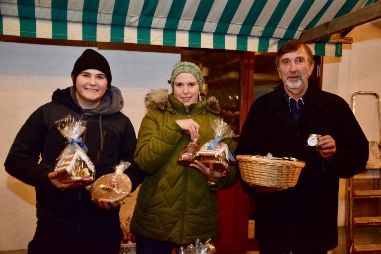 Felix Witwer von der Landjugend Oberland (l.) und Peter Bilgeri (Obmann des Bludenzer Liederkranzes) besuchten Maria Bolter am Marktstand des Freundeskreises des Franziskanerklosters.