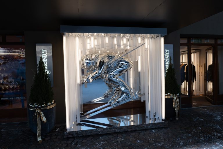 Die überdimensionale Skifahrer-Skulptur leuchtet vor dem Geschäft.