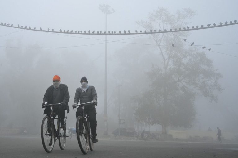 An einem kalten Wintermorgen in Amritsar in Indien fahren Menschen in extrem dichtem Nebel mit dem Fahrrad zur Arbeit. AFP