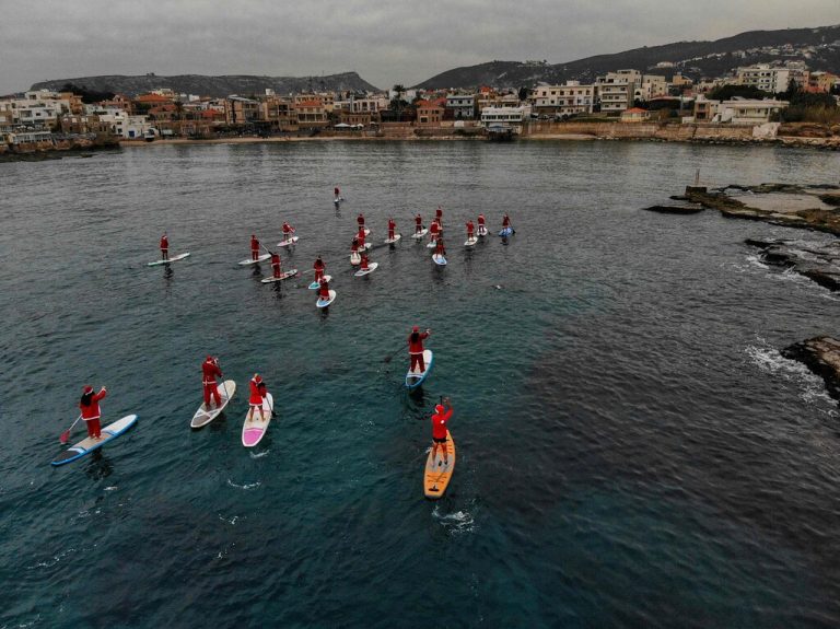 Diese Dohnenaufnahme zeigt Menschen in Weihnachtsmannkostümen, die in der nördlichen Küstenstadt Batroun im Libanon auf Stand-Up-Paddels fahren. AFP