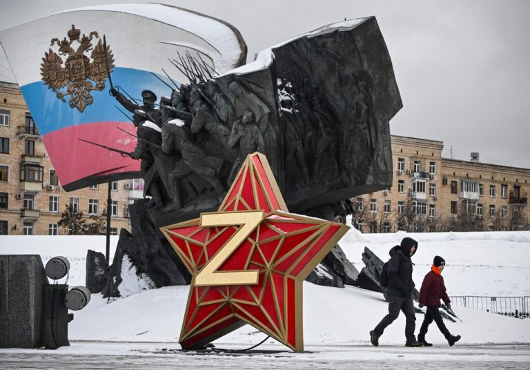 Menschen gehen in Moskau an einem Kremlstern mit dem Buchstaben Z vorbei. Das Z ist ein Abzeichen der russischen Truppen. AFP