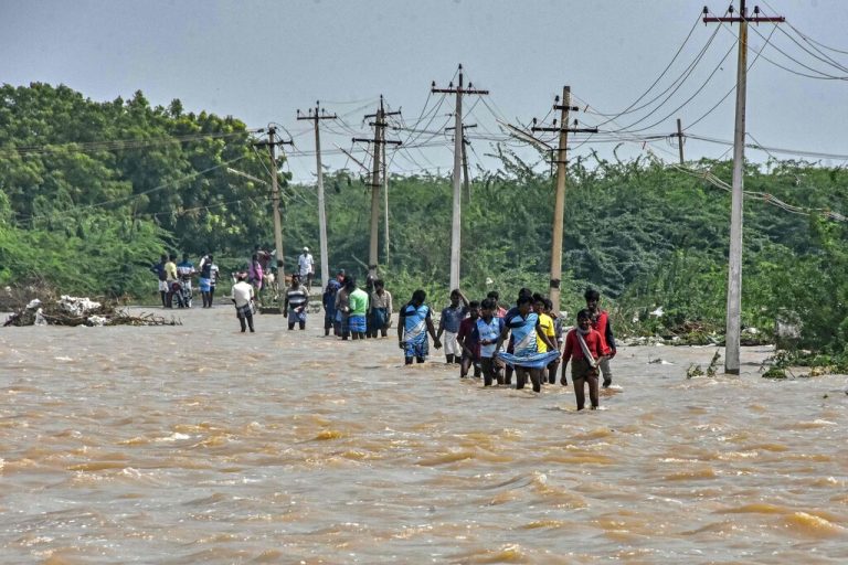 Nach heftigen Regenfällen in Thoothukudi in Südindien waten Menschen durch eine überflutete Straße. Mindestens zehn Personen kamen bei den Überschwemmungen ums Leben. AFP