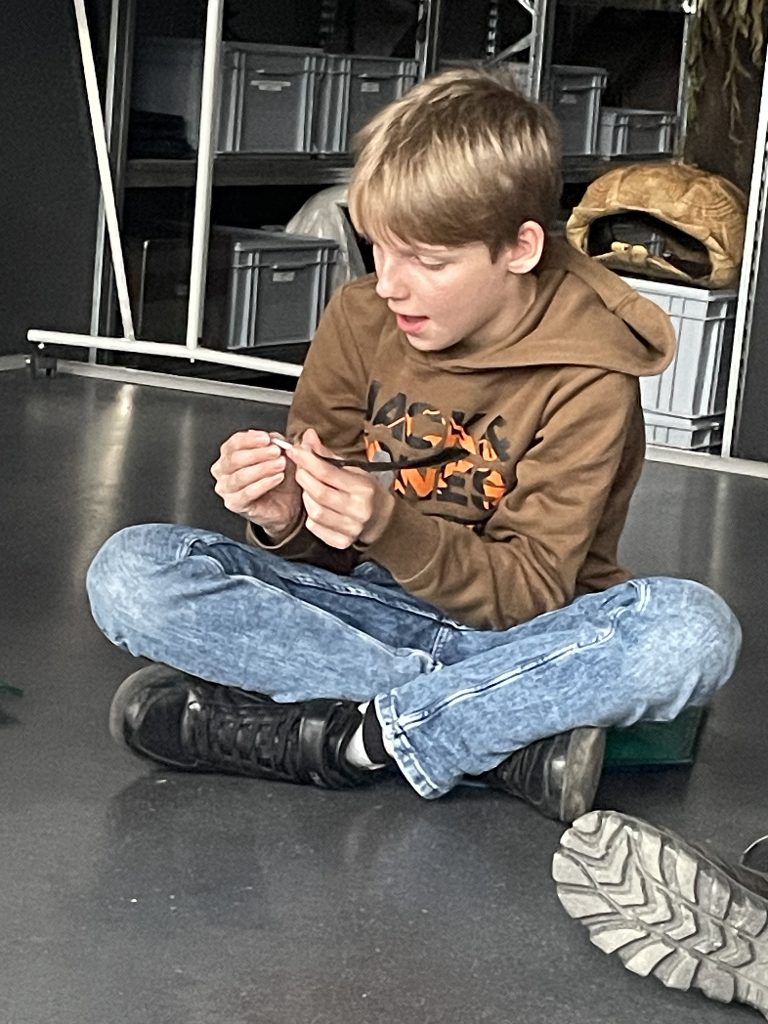 Elias untersucht die Feder ganz genau.