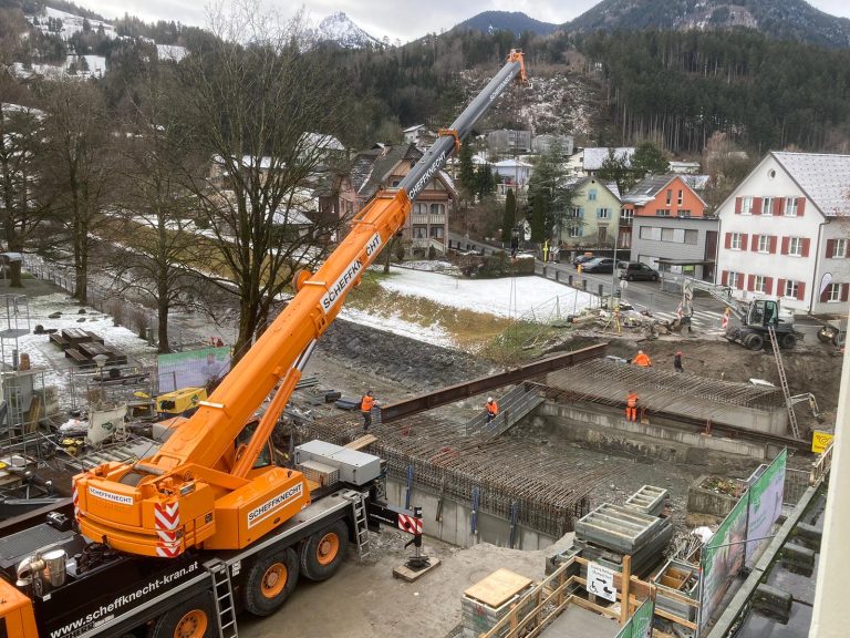 Der Telekran hievt aktuell die Stahlträger für das Lehrgerüst über die Samina.