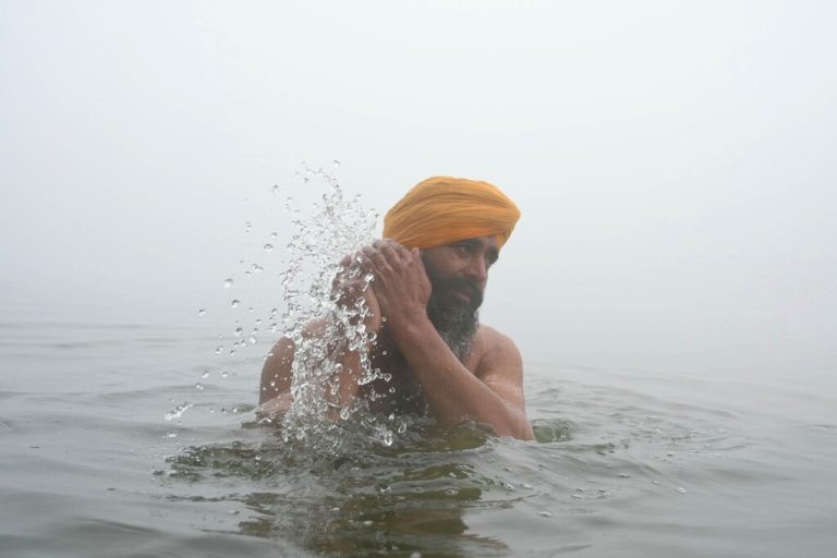 Ein Sikh-Anhänger erfrischt sich bei dichtem Nebel im Goldenen Tempel in Amritsar in Indien. AFP