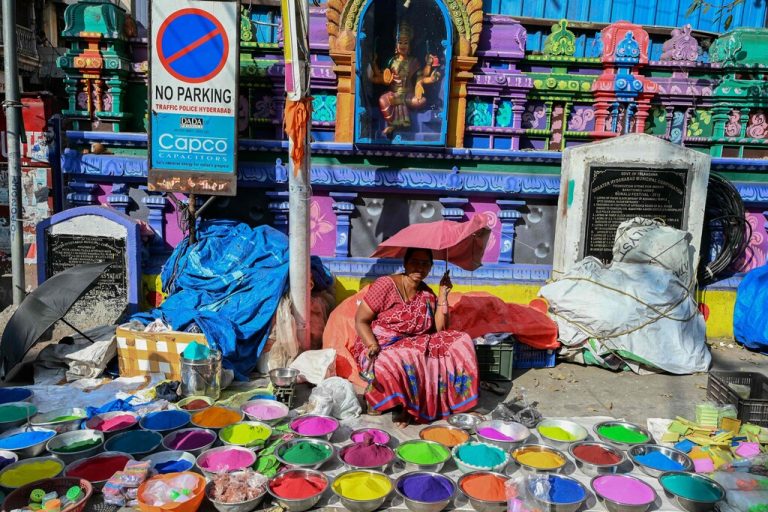 Eine Frau auf einem Markt in Hyderabad (Indien) bietet Farben für 