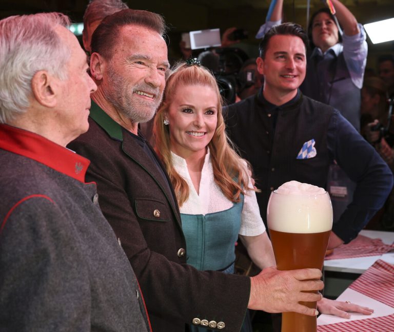 Karl Schranz (v.l.), Arnold Schwarzenegger, Heather Milligan und Andreas Gabalier mit einem übergroßen Weißbier. GEPA/Grebien