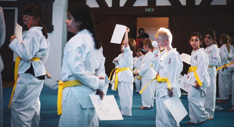 Eine Gruppe junger Taekwondo-Sportler zeigt bei einer Gürtelprüfung ihr Können.