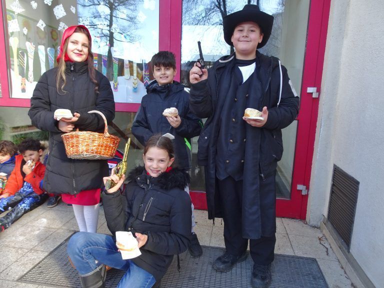 Alegra, Lena, Linus und Jonas stärkten sich mit Krapfen, bevor es zum großen Umzug durch das Hatlerdorf ging.