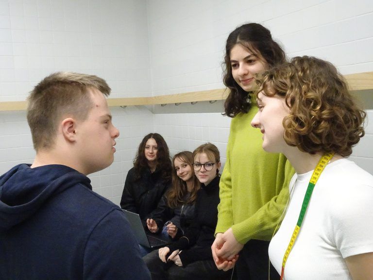 Angeregter Austausch zwischen den Designerinnen und ihren Models bei der letzten Anprobe. - Modische Inklusion auf dem Laufsteg - HTL-Maturantinnen präsentieren maßgeschneiderte Kleidung für Menschen mit Trisomie 21.