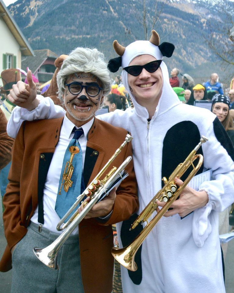 Zwei Musikanten der Harmoniemusik Bürs beim Faschingsumzug, gemeinsam mit ihrem Verein.