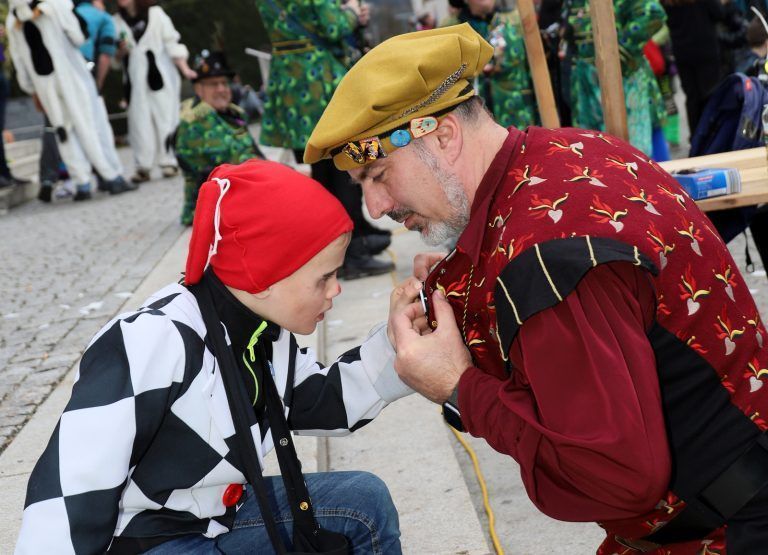 Ritter Wolfgang (r.) präsentierte einem faszinierten kleinen Harlekin die Faschingspins beim Hörbranzer Familienumzug. <span class="copyright">CHF/9</span>