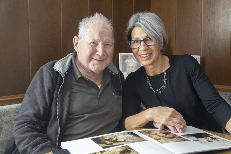 Rainer Knünz sieht sich mit seiner Tochter Rita Fotos aus der Vergangenheit an.