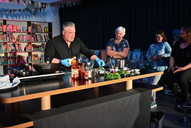 Direkt in der Bibliothek kochte er frisch für das Publikum und gab ihnen eine burmesische Kostprobe. - Dinner-Krimi in der Bibliothek - Dinner-Krimi in der Bibliothek