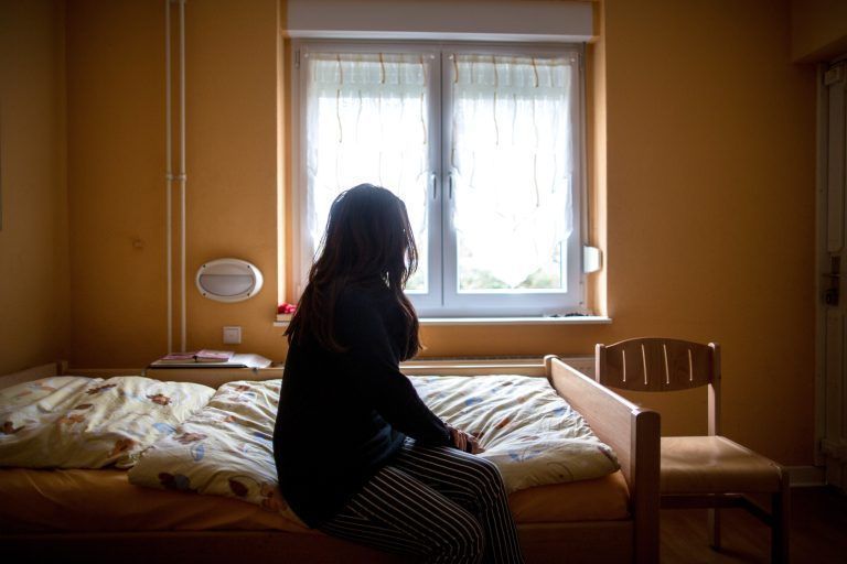 ABD0002_20220711 – HERNE – DEUTSCHLAND: ARCHIV – 12.11.2015, Nordrhein-Westfalen, Herne: Eine Frau sitzt in einem Frauenhaus auf einem Bett. Frauenhuser bieten Schutz, wenn der Partner zur Gefahr wird. Bayern hinkt beim Schutz von Frauen und Mdchen nach Ansicht der FDP hinter den eigenen Ansprchen und internationalen Absprachen hinterher. (zu dpa: “FDP: Bayern hinkt bei Schutz [&hellip;]