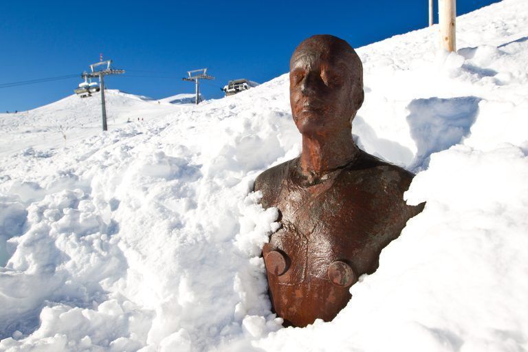 feature horizont field, eine eisenmannfigur ist beim diedamskopf bis zur brust von schnee bedeckt