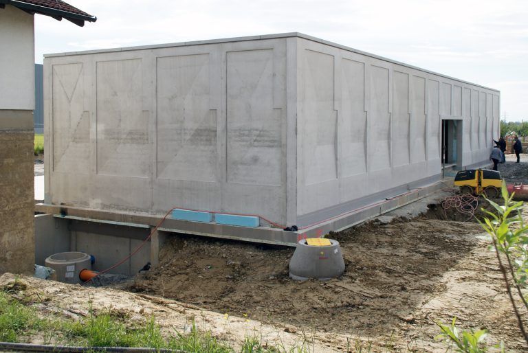 Vor dem Bau des neuen Pumpwerkgebäudes wurden der Trinkwasserbrunnen gebohrt und die beiden Wasserkammern unterirdisch errichtet. - Firstfeier Pumpwerk Straußen-Hörbranz