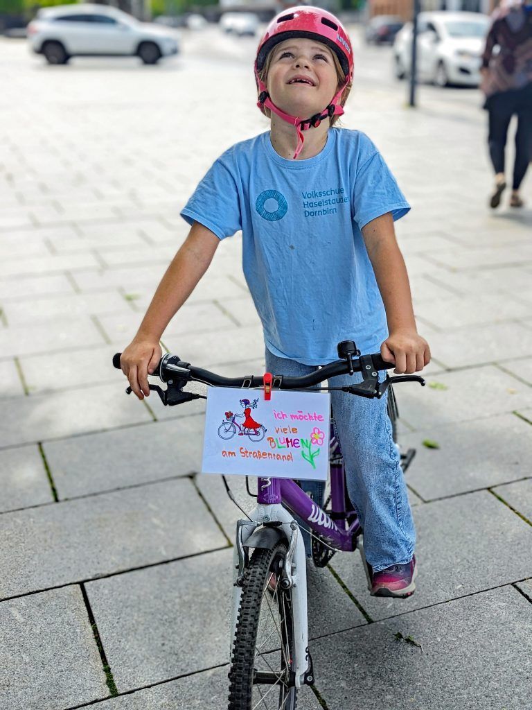 Dieses Kind wünscht sich mehr Blumen am Straßenrand. - "Kidical Mass" VS Haselstauden