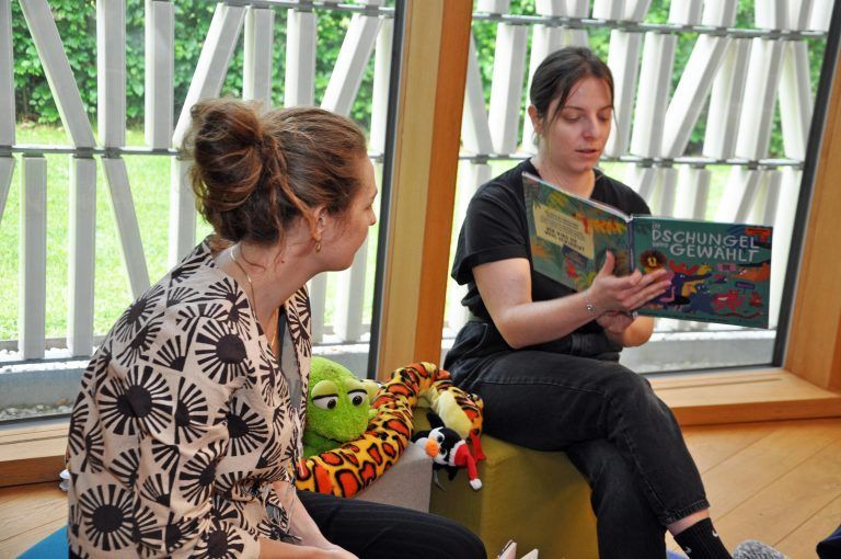 Silvana Kleiner (r.) und Naemi Sander lasen den Kindern aus „Im Dschungel wird gewählt!“ vor. - Wahl in der Kinderbibliothek