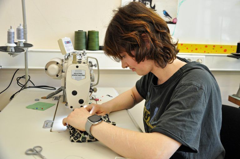 Die Mädchen nähen per Hand und mit der Nähmaschine. - Demenzdecken Kreativwerkstatt Job Ahoi
