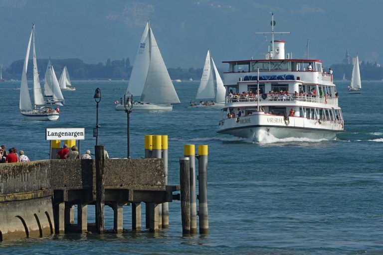 Das Passagierschiff "Karlsruhe" fährt am 18.08.2013 auf dem Bodensee die Anlegestelle von Langenargen an, während im Hintergrund einige Boote segeln. Foto: Felix Kästle/dpa +++(c) dpa - Bildfunk+++