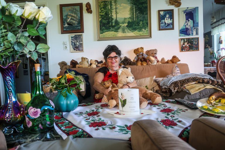 geschichte mit roswitha tieber, sie arbeitete viele Jahre als schrankenwärterin bei den festspielen, bitte fotos von ihr machen, im hintergrund mit ihrer ungewöhnlichen wohnung und auf dem balkon mit pflanzen