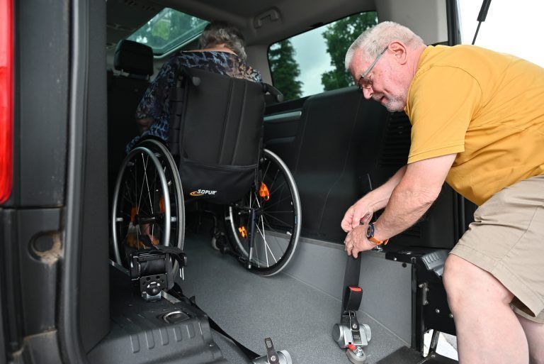 Gekonnt sichert Helmut Hagen den Rollstuhl, in dem dafür vorgesehenen Auto. - „Wir können noch was machen“ - „Wir können noch was machen“