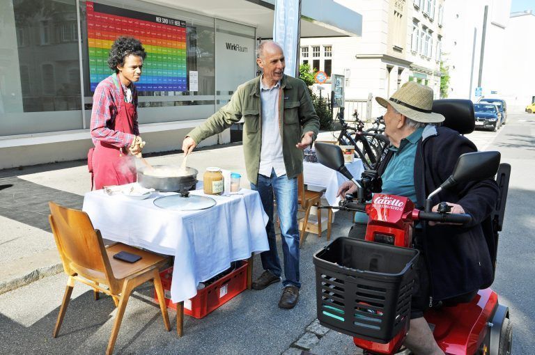 Ein Passant gab beim Stand der Lebenshilfe Tipps zum richtigen Riebel-Kochen. - Parking Day Dornbirn 2024